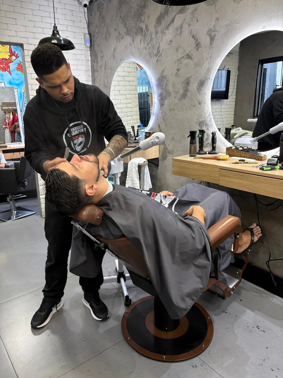 Barbeiro cuidando da barba de um cliente